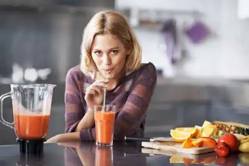 young, attractive woman drinking fresh fruit juice